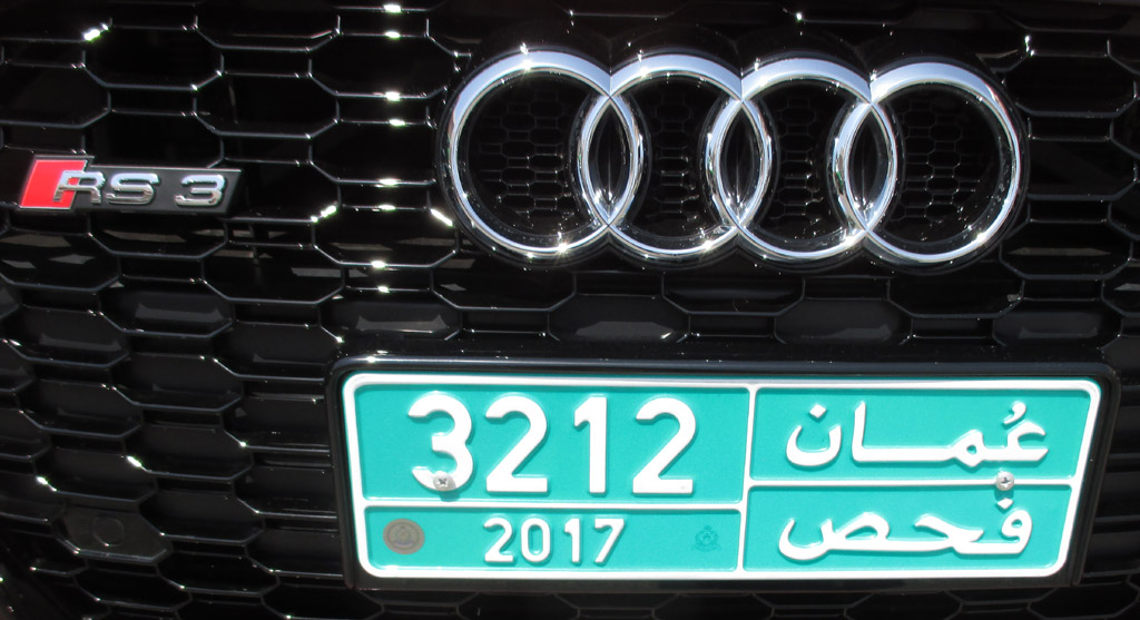 Audi RS3: Markenringe, Modellkennung und omanisches Kennzeichen im Kühlergrill.