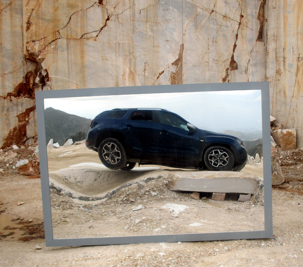 Spiegelbild des neuen Dacia Duster beim Achsverschränkungstest im Marmorsteinbruch.