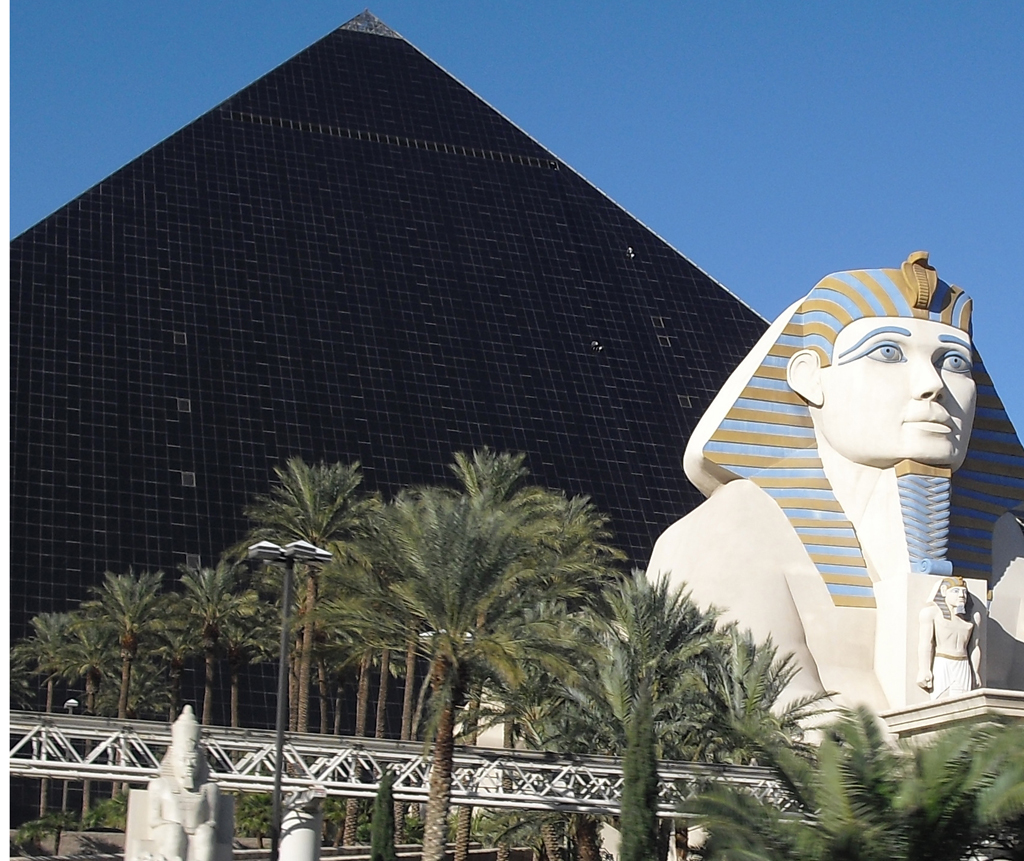 Gläsernes Pyramiden-Hotel Luxor mit weißer Sphinx-Statue davor.